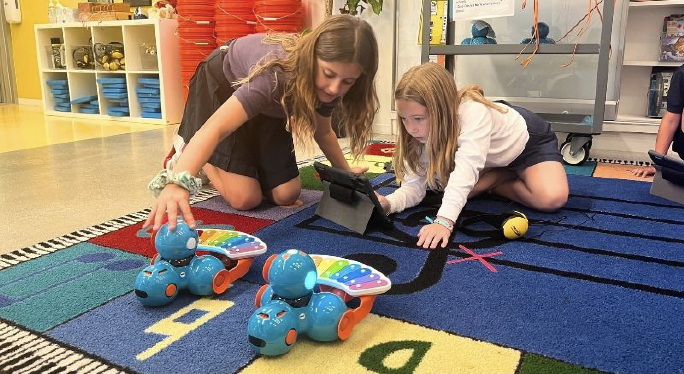 Students working with Dash robots and iPads